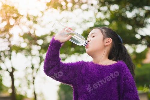 Preview: Beautiful Asian Girl Drinks Water From A Bottle Outdoors