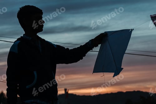 Preview: Silhouette Of An Indian Kid Holding Kite In His Hands During The Sunset At Makar Sankrati Festival