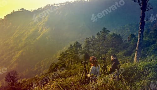 Preview: Two Of Mature Photographer Traveler Enjoying The Nature Taking Photo On Sunset Mountain Peak.Fiery