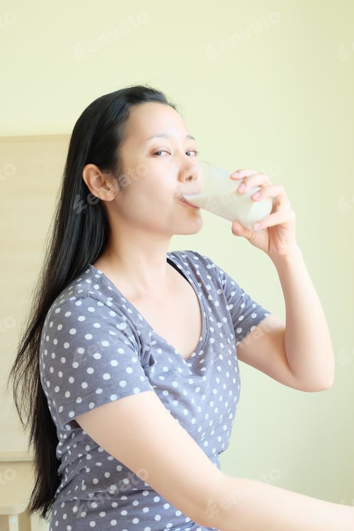 Preview: Healthy Asian Woman Is Drinking Milk From A Glass