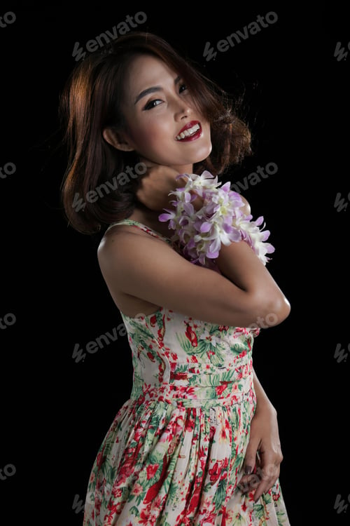 Preview: Beautiful Woman Half Body Posing With Orchid Flower Lei On Black Background.