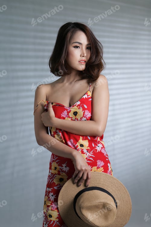 Preview: Beautiful South East Asian Woman Posing In Flower Print Slinky Red Dress In A Photography Studio
