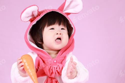Preview: Baby Dressed In Easter Bunny Ears With Carrot