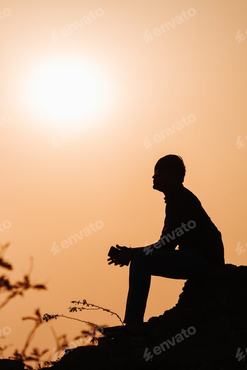 Preview: Silhouette Of An Indian Man Sitting In Front Of The Sunset At Wankaner, Gujarat, India