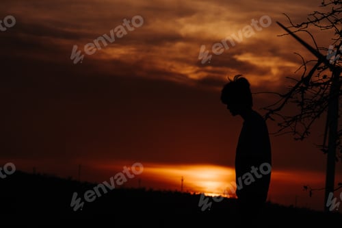 Preview: Silhouette Of A Man Standing In Front Of Trees And Windmill During Sunset