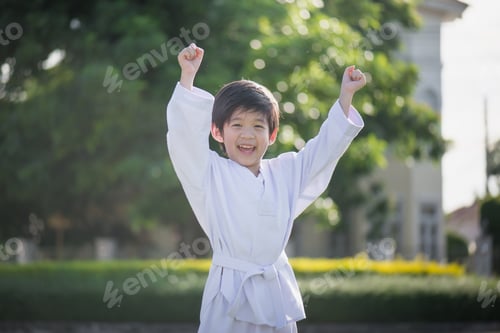 Preview: Cute Asian Child In White Kimono During Training Karate In Summer Outdoors