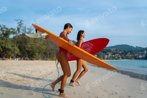 Preview: Confidence Asian Woman Girl Friends In Swimwear Holding Surfboard And Walking Together On The Beach