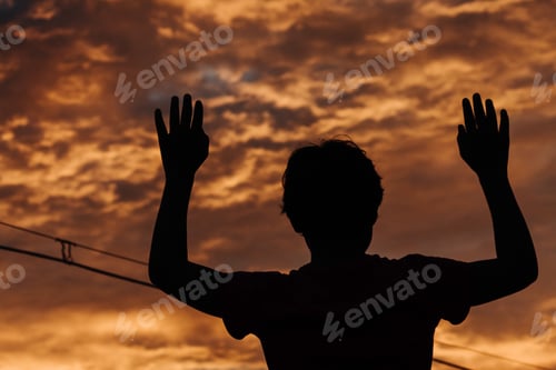 Preview: Silhouette Of A Kid Raising His Arms In Front Of The Beautiful Sunset