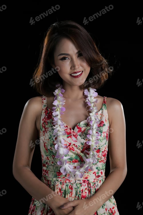 Preview: Beautiful Woman Half Body Posing With Orchid Flower Lei On Black Background.