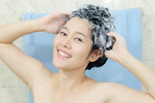 Preview: Smiling Woman Washing Hair in Bathroom