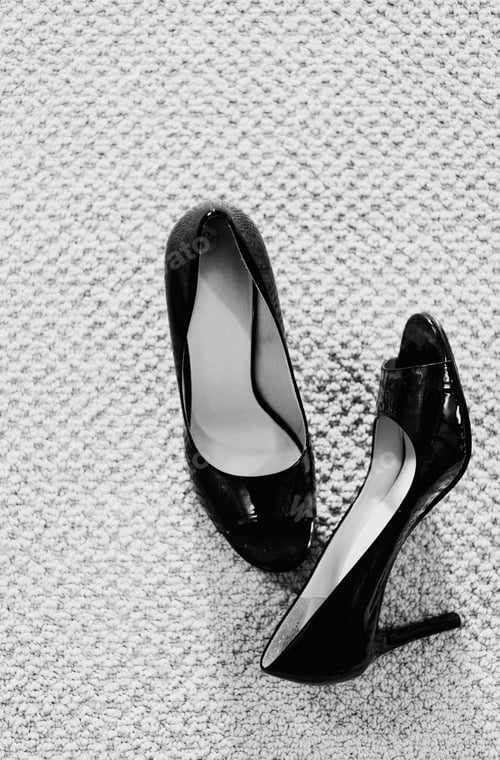 Preview: A Pair Of Black High Heel Shoes On A Carpet.