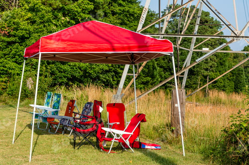 Preview: Empty Folding Chairs Sitting Along Side A Road Under A Canopy
