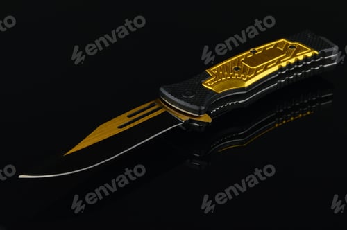 Preview: A Black And Gold Pocket Knife Over A Reflective Surface.