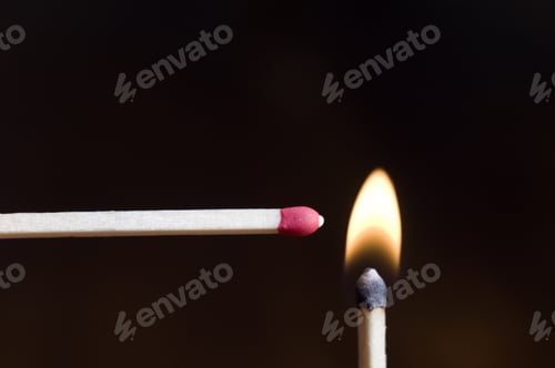 Preview: An Unlit Match Being Held Against A Lit Match.