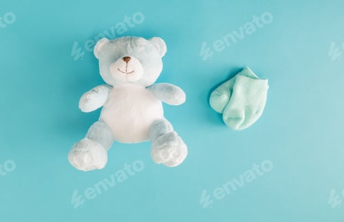Preview: Baby Teddy Bear And Socks On A Blue Background