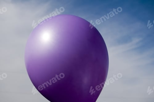 Preview: A Purple Balloon Against A Cloudy Blue Sky.