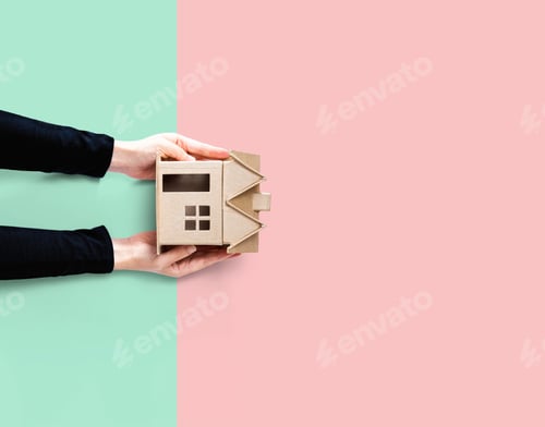 Preview: Woman Holding A Cardboard House Overhead View