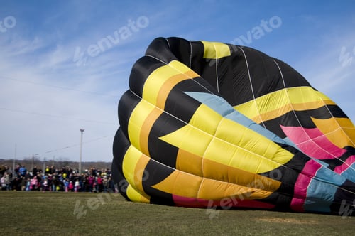 Preview: A Multicolored Hot Air Balloon And A Crowd Of People.