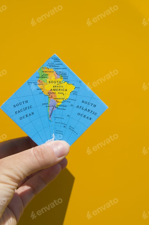 Preview: A Person Holding A Folded Map Of The Earth.