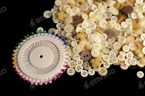 Preview: A Closeup Of Sewing Pins And Buttons Over A Black Reflective Surface.
