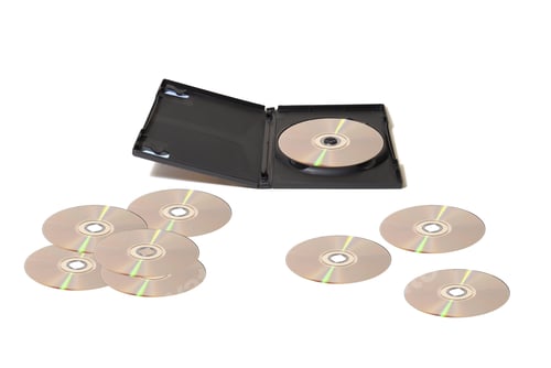 Preview: A Dvd Collection With Scattered Disks Over A White Table.
