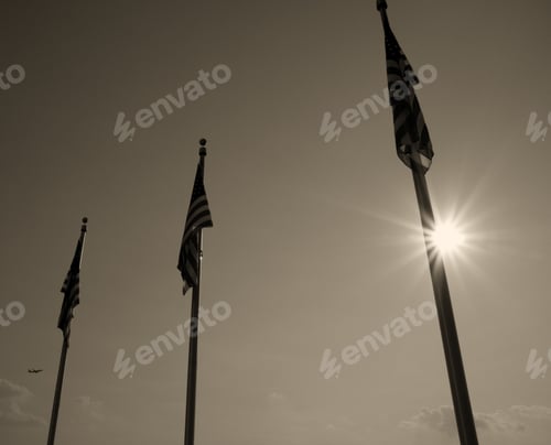 Preview: Three Flags Are Limp In Front Of The Sky And Sun.