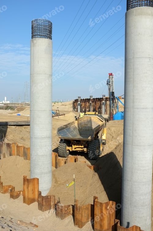 Preview: Bridge Construction Project: Dump Truck Delivers Soil For Backfilling Around Concrete Columns