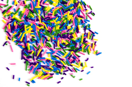 Preview: Hundreds Of Multicolored Candy Strands Are Scattered Across A White Surface.