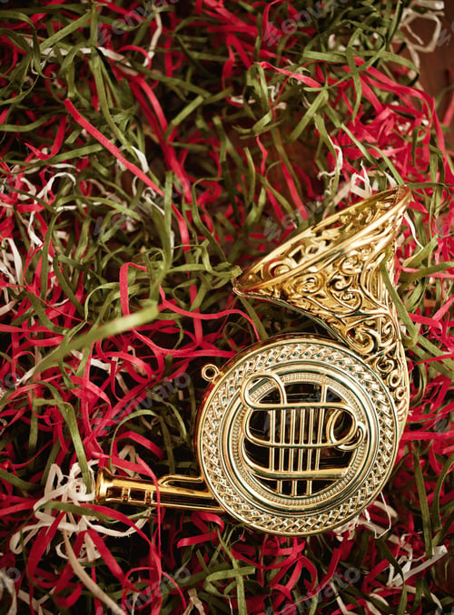Preview: A Gold Ornament Lying On Green And Red Ribbons.