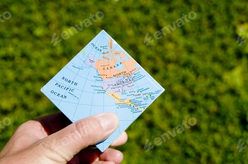 Preview: A Square Map Of The World Being Held With Grass In The Background.