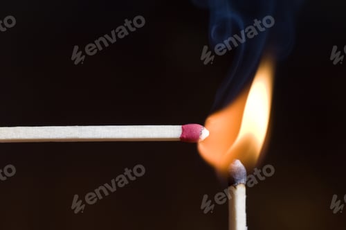 Preview: Two Matches Both Lit With An Orange Flame.