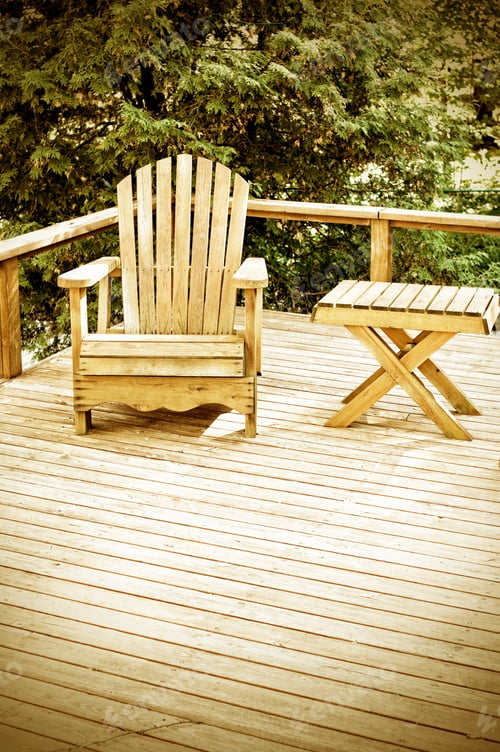 Preview: A Wooden Chair And Table On A Deck Overlooking A Wooded Area.