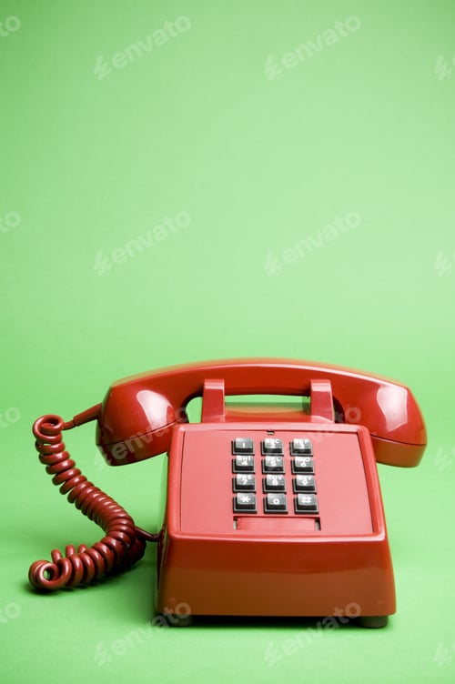 Preview: An Older Type Of Phone On A Green Background.