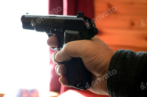 Preview: Closeup Of A Man Holding A Hand Gun Ready To Shoot.