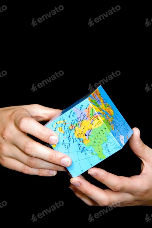Preview: Hands Holding A Cube With A Map Of The World On It.