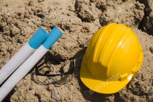 Preview: A Yellow Cap And Two White Sticks On Rocks.