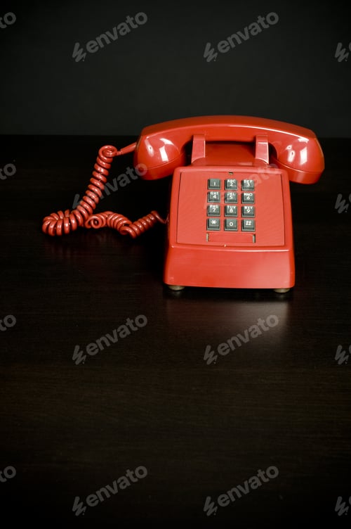 Preview: Red Wired Telephone On A Dark Brown Surface.