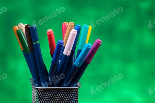 Preview: Creativity Of Colorful Colored Pen In Pencil Case With Copy Space On Blurred Green Background.