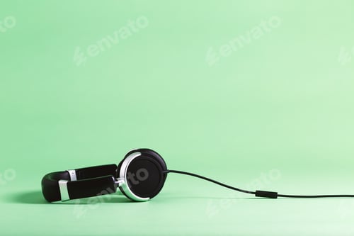 Preview: Pair Of Black Headphones On A Green Background