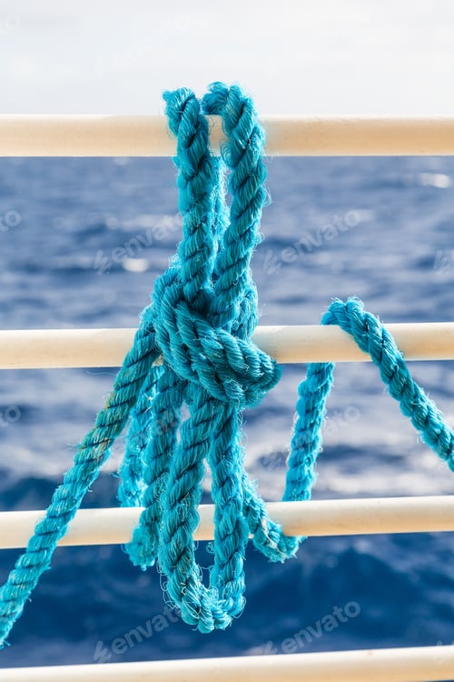Preview: A Blue Rope Tied To The White Railing Of A Ship With Blue Sea In Background