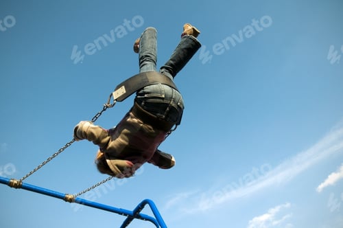 Preview: A Child On A Blue Swing Set As They Swing Towards The Sky.