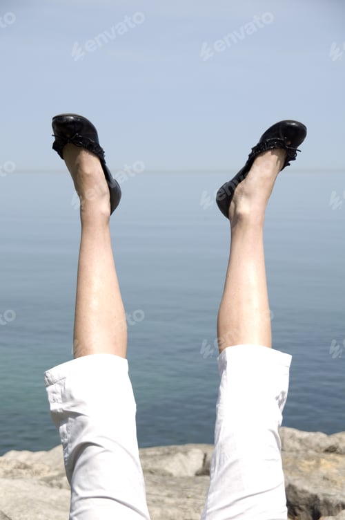 Preview: A Pair Of Legs In The Air With Black Pumps On The Feet.