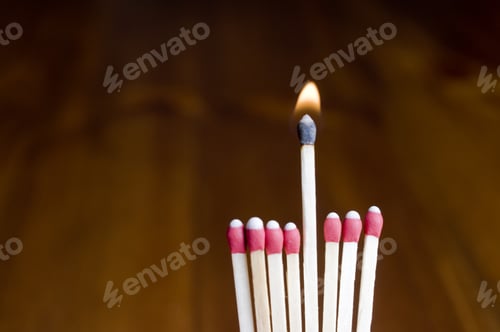 Preview: Eight Wooden Matchsticks Lined Up With The Fifth One Raised And Burning.