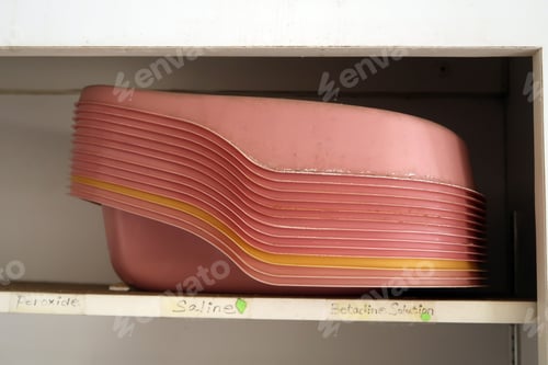 Preview: Stack Of Neglected And Forgotten Pink Bedpans. Natural Light.