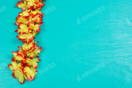 Preview: Yellow And Red Hawaiian Necklace On Blue Background With Space For Text