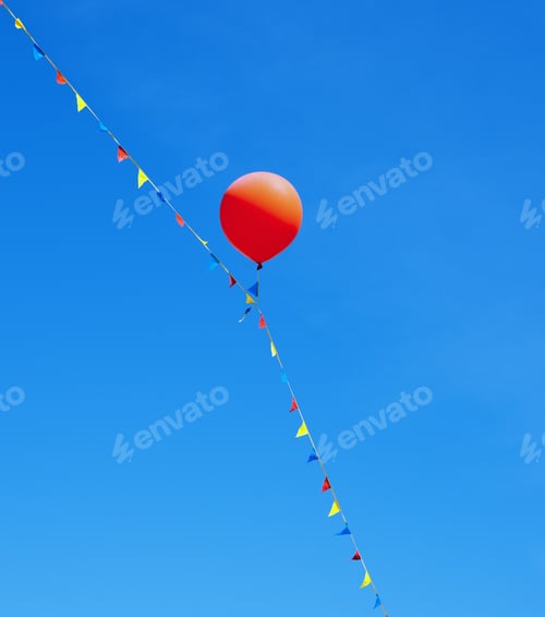 Preview: A Red Balloon And Multicolored Flags On A String Against A Clear Blue Sky.
