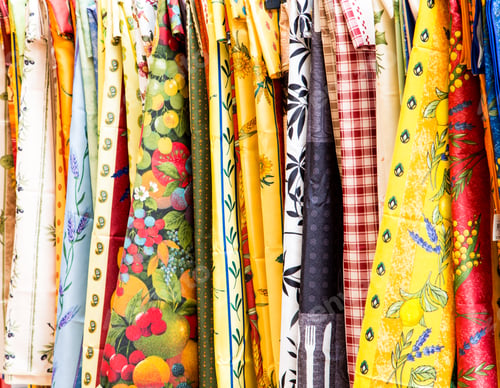 Preview: An Assortment Of Colorful Tablecloths Hanging On A Rack In A Market
