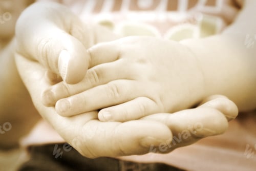 Preview: An Affectionate Shot Of Mothers Hand Holding Her Baby Girls Hand. A Vintage Technique Was Used On A