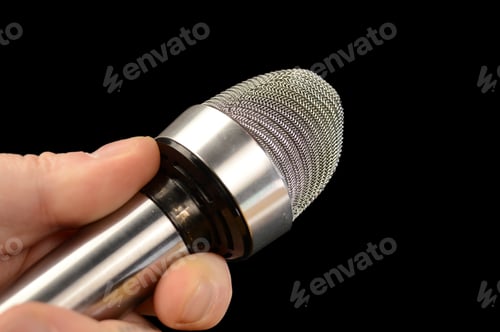 Preview: An Interviewing Reporter Using His Microphone Over A Black Background.