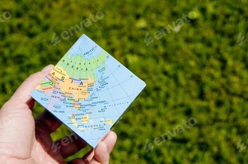 Preview: A Cube Interpretation Of The Earth Being Held Above The Ground.